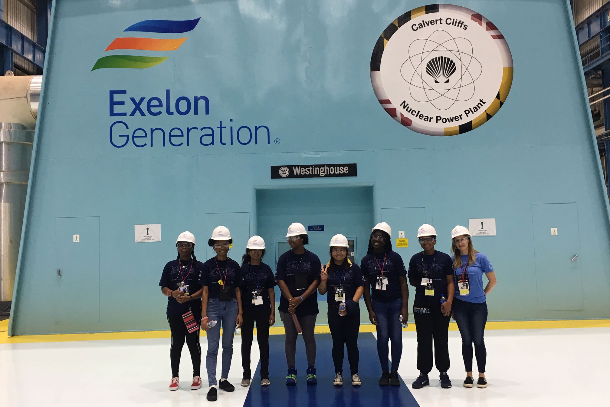 Students in hard hats outside a nuclear power plant