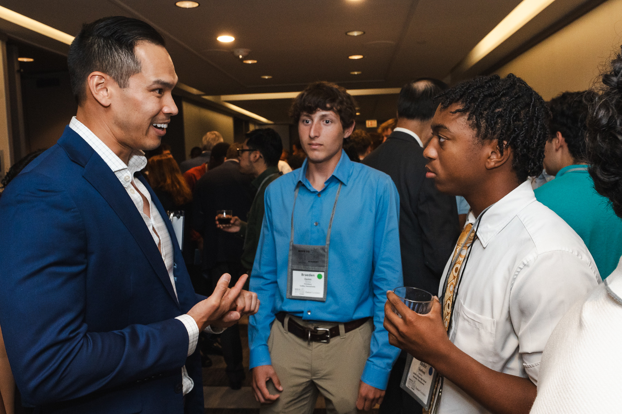 Students in discussion with an adult in a suit