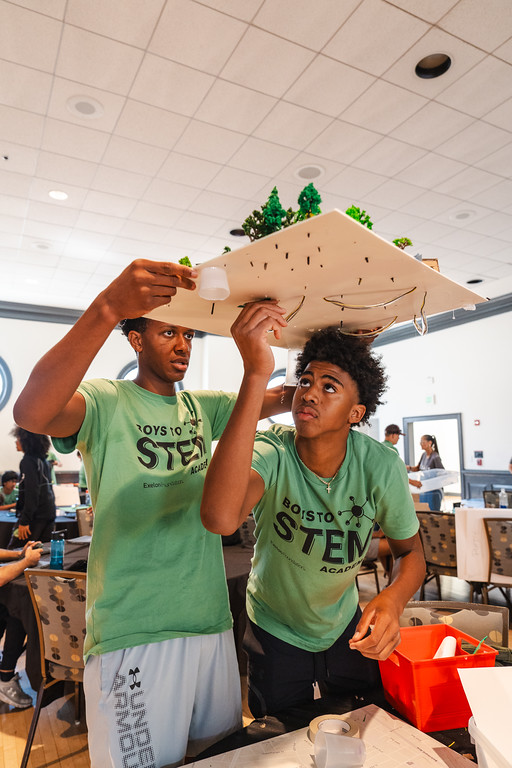 Two boys inspecting their STEM project