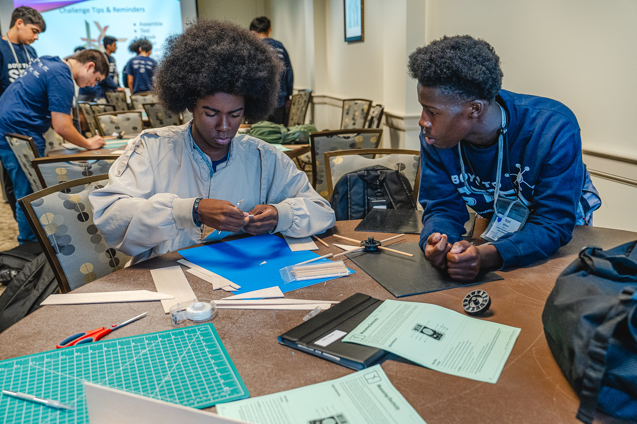 Students seated at a table working on a school project